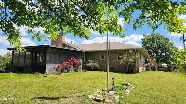 3002 S Main St, Galena, KS 66739 - back of house with a sunroom, a chimney, a yard, and brick siding