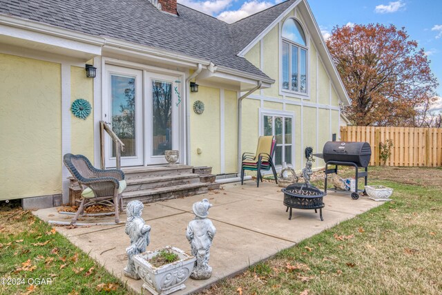 607 S Morgan Ct, Joplin, MO 64801 - rear view of house with a shingled roof, entry steps, stucco siding, a fire pit, and a patio