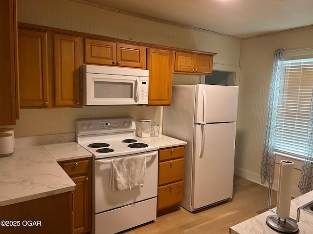 507 W Hill St, Neosho, MO 64850 - kitchen featuring white appliances, brown cabinets, light wood-style flooring, light stone counters, and healthy amount of natural light