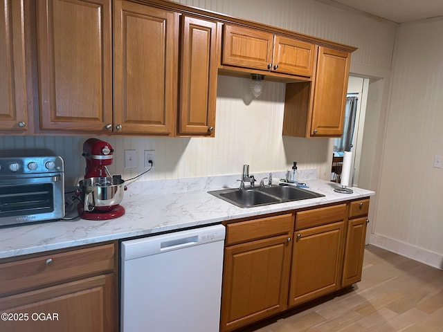 507 W Hill St, Neosho, MO 64850 - kitchen with white dishwasher, brown cabinets, light wood-type flooring, and light stone counters