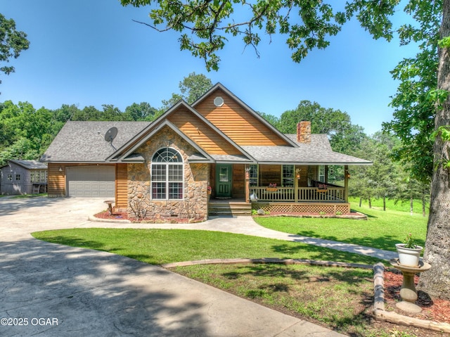 9404 County Lane 121, Carthage, MO 64836 - view of front facade featuring stone siding, concrete driveway, a chimney, covered porch, and a front yard