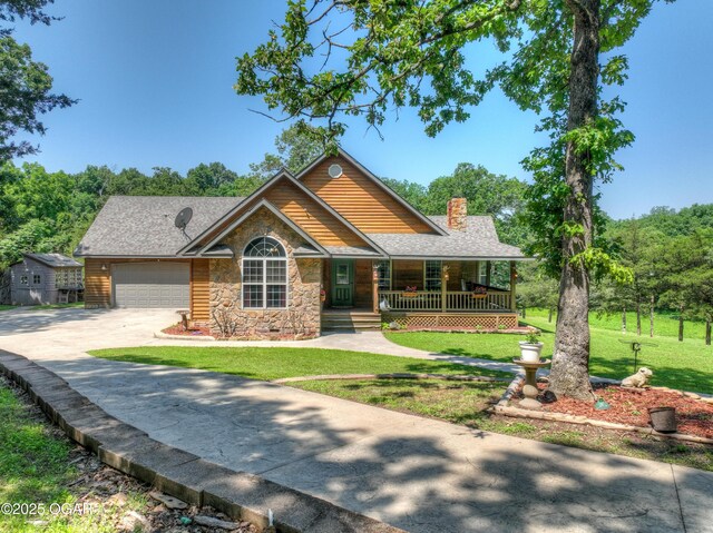 9404 County Lane 121, Carthage, MO 64836 - view of front facade with stone siding, covered porch, driveway, a chimney, and a front yard