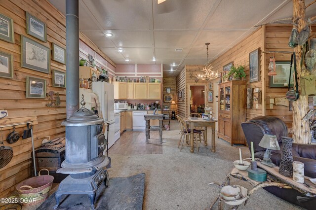9404 County Lane 121, Carthage, MO 64836 - living area with wood walls, a wood stove, light colored carpet, and a chandelier