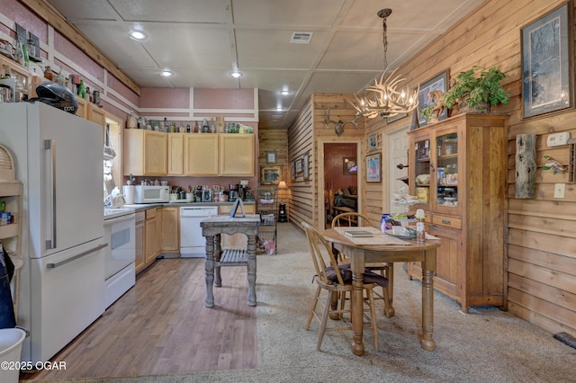 9404 County Lane 121, Carthage, MO 64836 - kitchen featuring white appliances, wood walls, light brown cabinetry, a chandelier, and decorative light fixtures