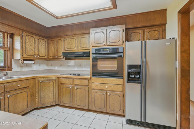 5694 Spurgeon Rd, Joplin, MO 64804 - kitchen with black appliances, light tile patterned floors, brown cabinets, and extractor fan