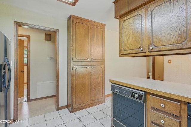 5694 Spurgeon Rd, Joplin, MO 64804 - kitchen featuring black dishwasher, refrigerator with ice dispenser, light countertops, light tile patterned floors, and brown cabinets