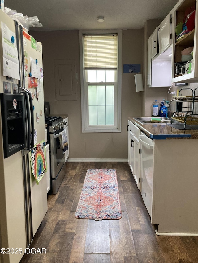 524 W 2nd St, Webb City, MO 64870 - kitchen with white refrigerator with ice dispenser, stainless steel gas stove, dishwashing machine, dark wood finished floors, and white cabinetry
