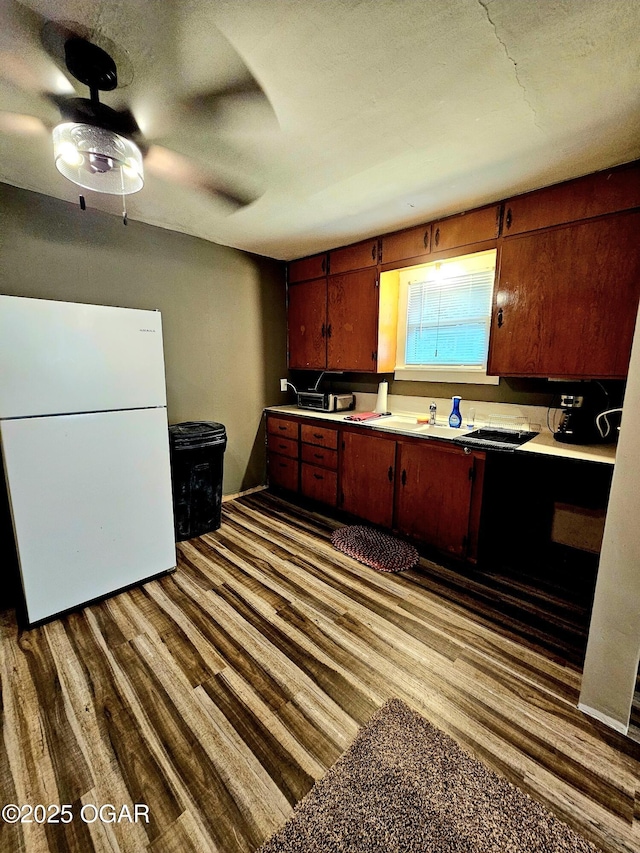 1109 Lincoln Ave, Baxter Springs, KS 66713 - kitchen with freestanding refrigerator, dark wood finished floors, a ceiling fan, light countertops, and a textured ceiling