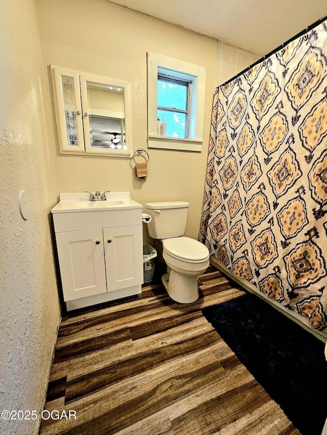 1109 Lincoln Ave, Baxter Springs, KS 66713 - full bath featuring wood finished floors, vanity, a shower with curtain, and a textured wall