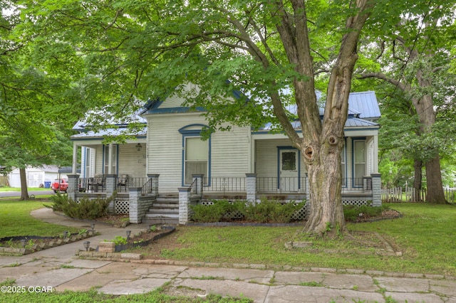 117 S 11th St, Sarcoxie, MO 64862 - view of front of house featuring covered porch, a metal roof, and a front lawn