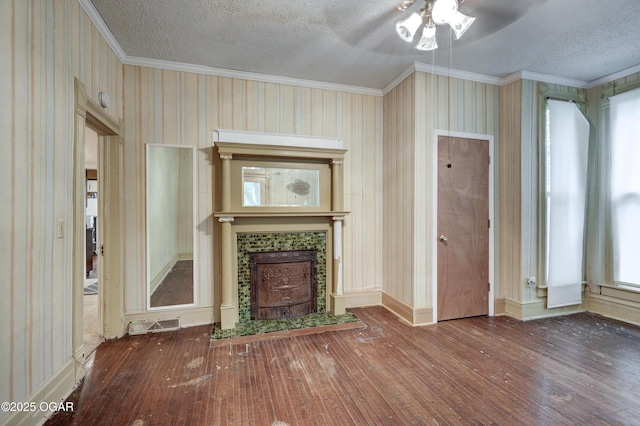 117 S 11th St, Sarcoxie, MO 64862 - unfurnished living room with ornamental molding, hardwood / wood-style floors, ceiling fan, a textured ceiling, and a tiled fireplace