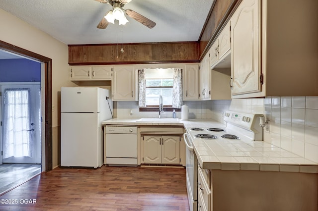 117 S 11th St, Sarcoxie, MO 64862 - kitchen featuring white appliances, tile counters, backsplash, ceiling fan, and dark wood-style flooring