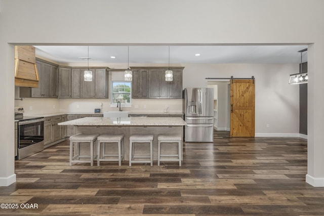 4610 W Amber Rd, Joplin, MO 64804 - kitchen featuring stainless steel appliances, dark wood-type flooring, a breakfast bar area, a barn door, and recessed lighting
