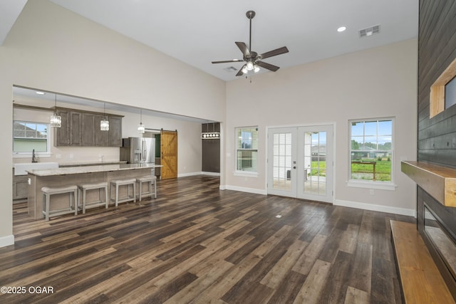 4610 W Amber Rd, Joplin, MO 64804 - living area featuring a towering ceiling, a barn door, a ceiling fan, dark wood-type flooring, and a fireplace