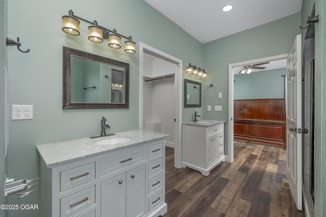 4610 W Amber Rd, Joplin, MO 64804 - bathroom with two vanities, wood finished floors, ceiling fan, and recessed lighting