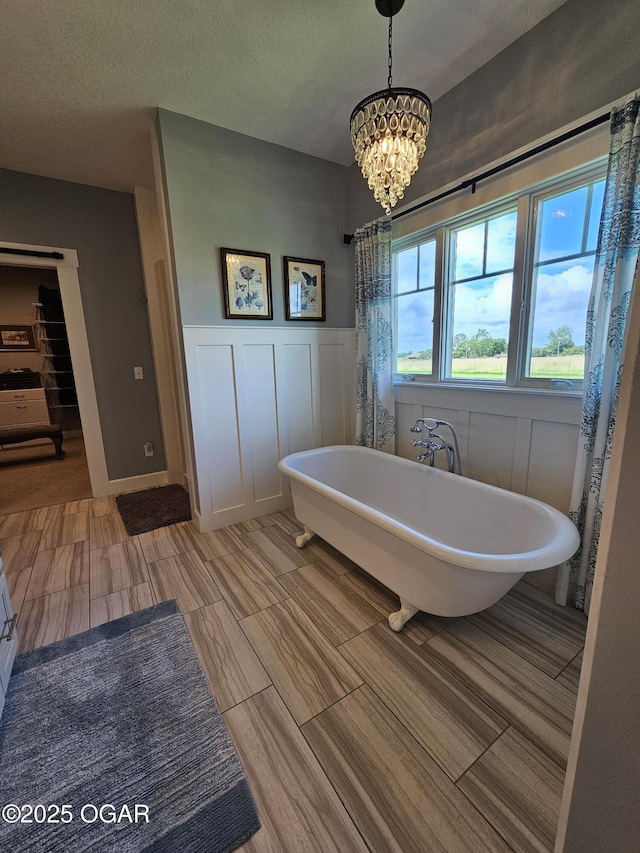 12673 Ibex Rd, Neosho, MO 64850 - full bathroom featuring a chandelier, a freestanding bath, and wainscoting