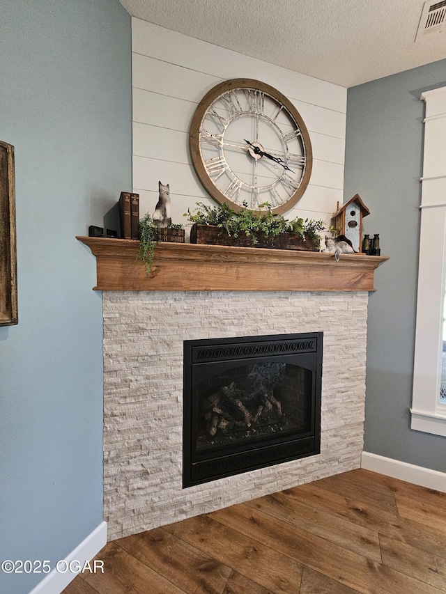 12673 Ibex Rd, Neosho, MO 64850 - detailed view of wood finished floors, a fireplace, wooden walls, and a textured ceiling
