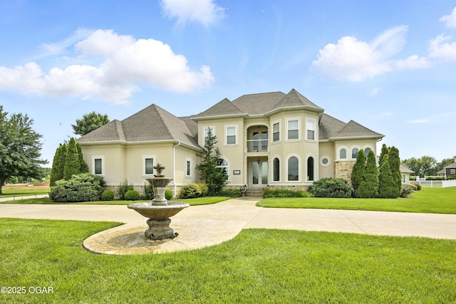 1641 Alexandra Dr, Carthage, MO 64836 - french provincial home with stucco siding, stone siding, a front lawn, and curved driveway