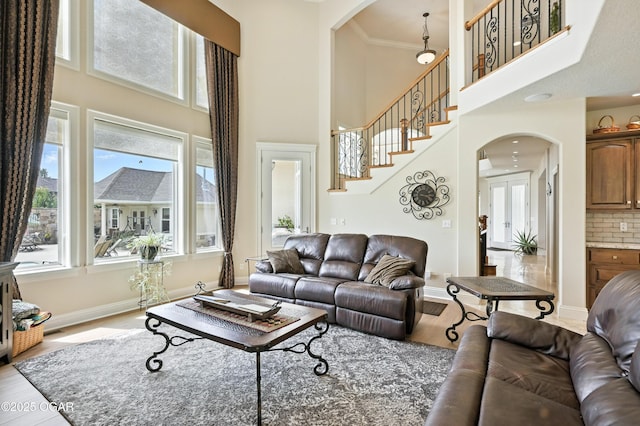 1641 Alexandra Dr, Carthage, MO 64836 - living area with arched walkways, a high ceiling, wood finished floors, and stairs