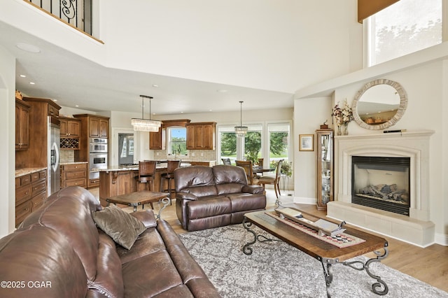 1641 Alexandra Dr, Carthage, MO 64836 - living area featuring a towering ceiling, light wood-style floors, recessed lighting, and a glass covered fireplace