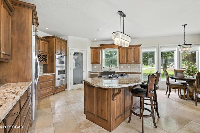 1641 Alexandra Dr, Carthage, MO 64836 - kitchen with a warming drawer, appliances with stainless steel finishes, backsplash, light stone counters, and a center island