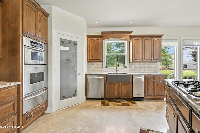 1641 Alexandra Dr, Carthage, MO 64836 - kitchen featuring a warming drawer, appliances with stainless steel finishes, backsplash, light stone countertops, and brown cabinets