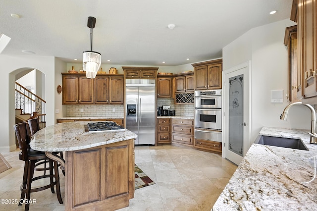 1641 Alexandra Dr, Carthage, MO 64836 - kitchen with stainless steel appliances, a warming drawer, decorative backsplash, arched walkways, and recessed lighting