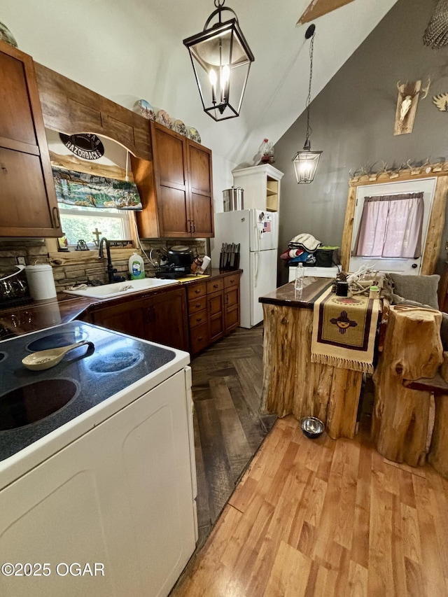 17568 Jordan Ln, Neosho, MO 64850 - kitchen featuring white appliances, lofted ceiling, tasteful backsplash, decorative light fixtures, and dark countertops