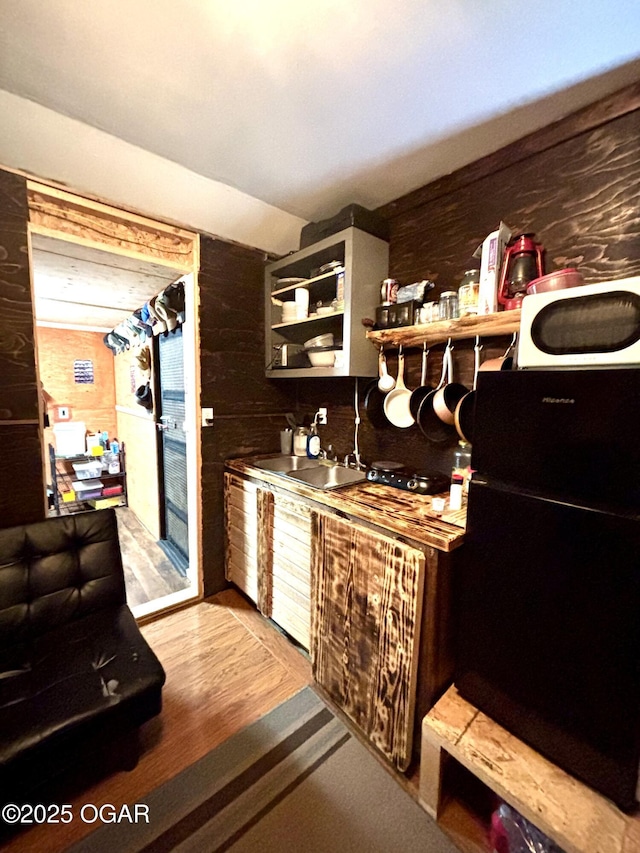 17568 Jordan Ln, Neosho, MO 64850 - bar with freestanding refrigerator, white microwave, wood walls, and wood finished floors