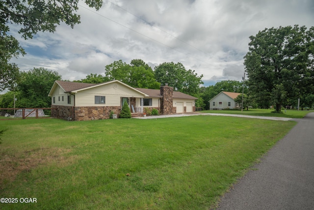 214 S Ozark Trl, Goodman, MO 64843 - ranch-style house featuring stone siding, concrete driveway, an attached garage, and a chimney
