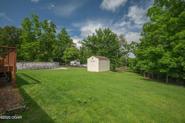 214 S Ozark Trl, Goodman, MO 64843 - view of yard with a storage unit, view of wooded area, a wooden deck, and a swimming pool