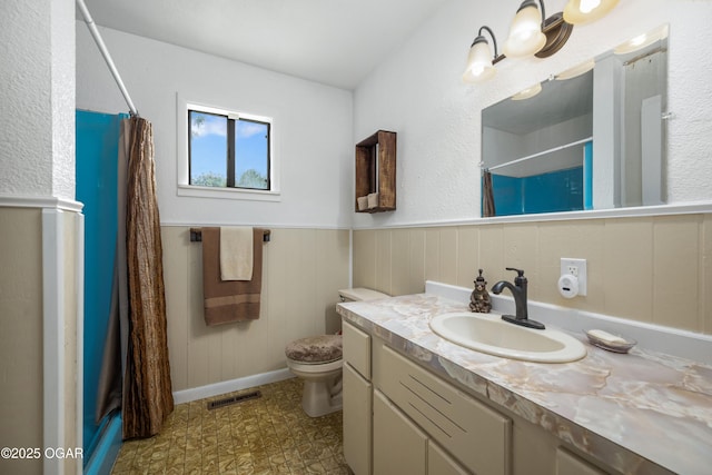 214 S Ozark Trl, Goodman, MO 64843 - full bathroom with curtained shower, vanity, tile patterned floors, and wainscoting