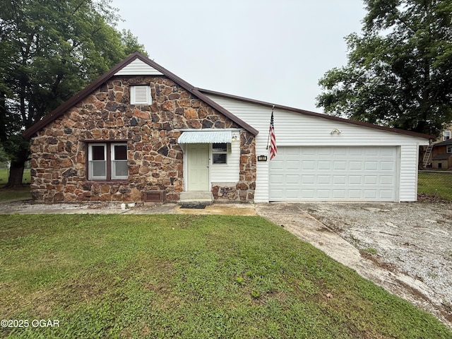 1310 Regan Ave, Carthage, MO 64836 - view of front of property featuring stone siding, driveway, a front yard, and an attached garage