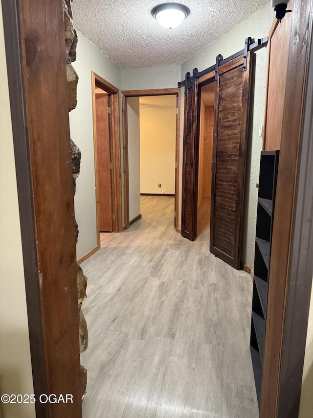 1310 Regan Ave, Carthage, MO 64836 - hallway with a textured ceiling, wood finished floors, and a barn door