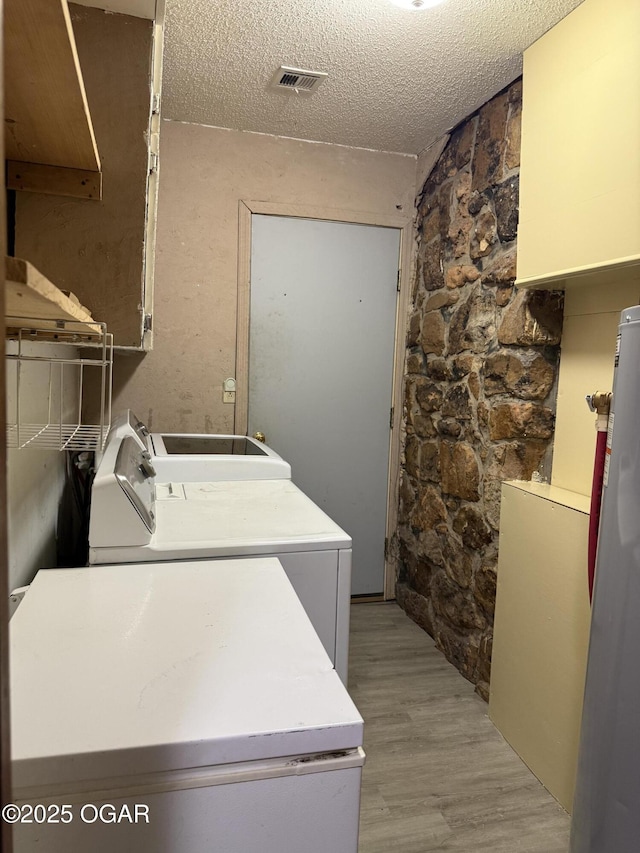 1310 Regan Ave, Carthage, MO 64836 - laundry room featuring washer and dryer, light wood-style floors, and a textured ceiling