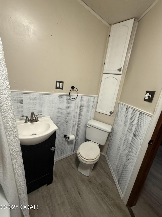 1310 Regan Ave, Carthage, MO 64836 - bathroom with wood finished floors, vanity, a wainscoted wall, and tile walls