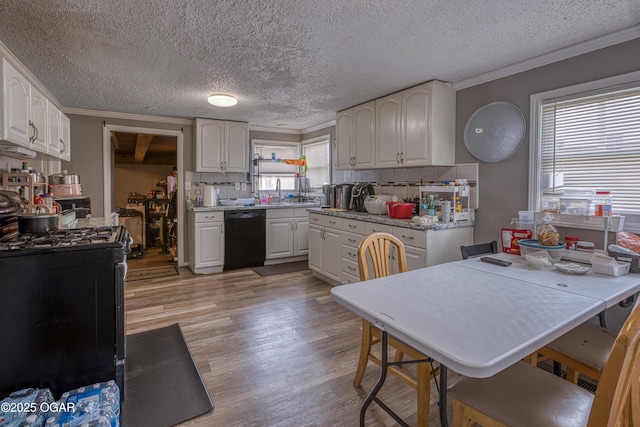 602 N Grand St, Pittsburg, KS 66762 - kitchen with black dishwasher, gas range, crown molding, light wood-style floors, and white cabinetry