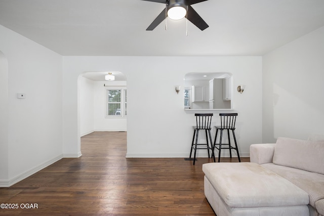 424 S Mcconnell Ave, Joplin, MO 64801 - living area with arched walkways, a ceiling fan, and dark wood finished floors