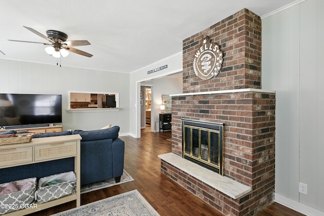 301 N 1st St, Jasper, MO 64755 - living area featuring wood finished floors, a ceiling fan, a brick fireplace, and crown molding