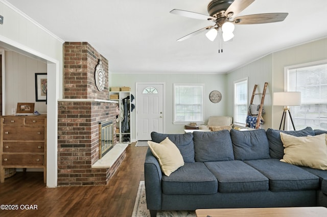 301 N 1st St, Jasper, MO 64755 - living room featuring a brick fireplace, ornamental molding, wood finished floors, and a ceiling fan
