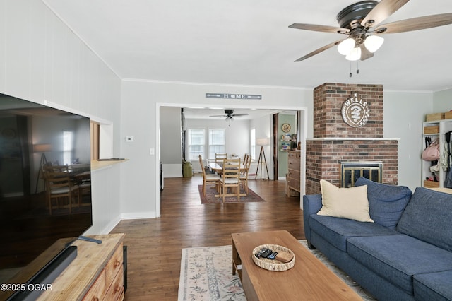 301 N 1st St, Jasper, MO 64755 - living room with a ceiling fan, dark wood-style floors, a brick fireplace, and crown molding