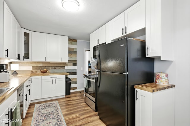 301 N 1st St, Jasper, MO 64755 - kitchen with black appliances, wood counters, white cabinets, and glass insert cabinets