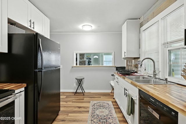301 N 1st St, Jasper, MO 64755 - kitchen featuring black appliances, butcher block counters, light wood finished floors, white cabinets, and ornamental molding