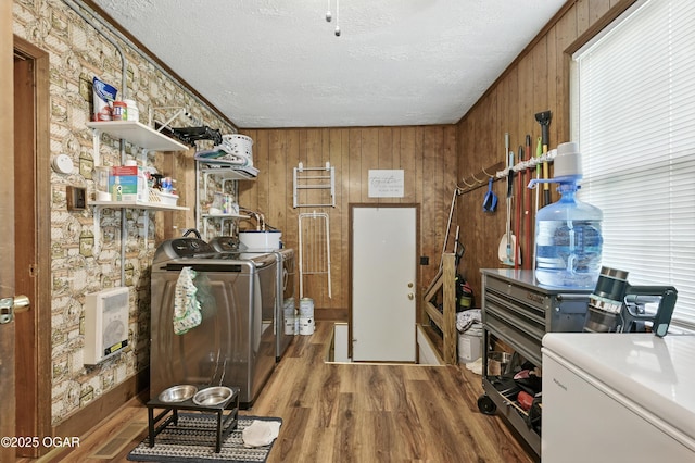 301 N 1st St, Jasper, MO 64755 - laundry room featuring separate washer and dryer, a textured ceiling, wood finished floors, wood walls, and heating unit