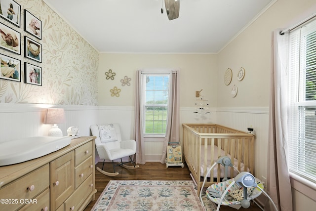 301 N 1st St, Jasper, MO 64755 - bedroom featuring a wainscoted wall, a nursery area, dark wood-style flooring, ornamental molding, and ceiling fan