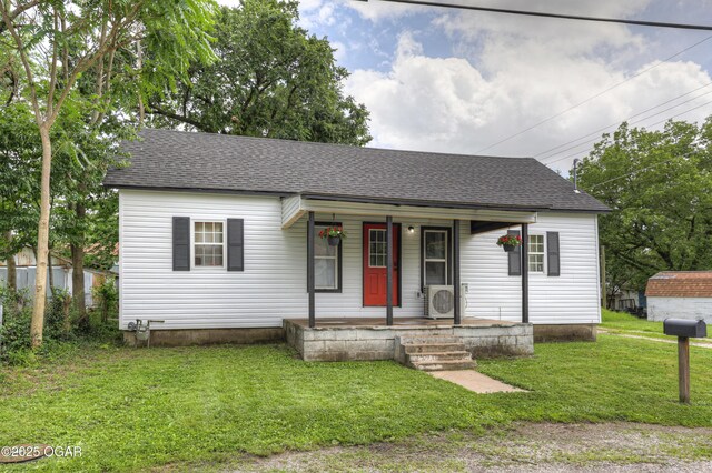 421 W 6th St, Baxter Springs, KS 66713 - view of front of property with a porch, a shingled roof, and a front yard