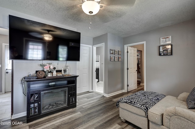 421 W 6th St, Baxter Springs, KS 66713 - living area featuring ceiling fan, wood finished floors, and a textured ceiling
