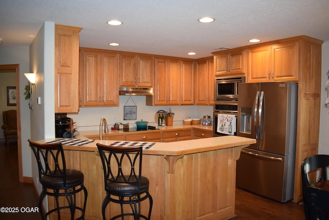 1902 E Natalie Ln, Joplin, MO 64801 - kitchen featuring appliances with stainless steel finishes, under cabinet range hood, a peninsula, recessed lighting, and a kitchen bar