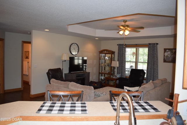 1902 E Natalie Ln, Joplin, MO 64801 - living area featuring a ceiling fan, wood finished floors, a tray ceiling, a textured ceiling, and recessed lighting