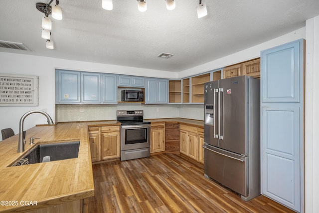 645 Worth St, Granby, MO 64844 - kitchen with appliances with stainless steel finishes, open shelves, dark wood-type flooring, decorative backsplash, and a peninsula